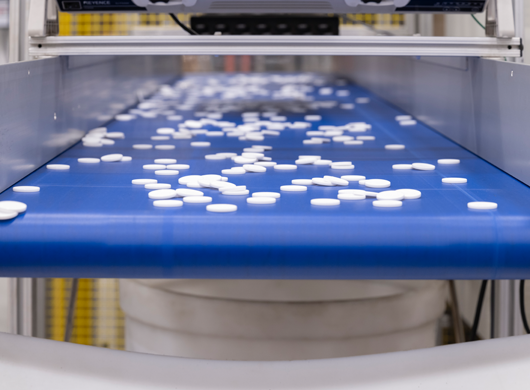 white plastic parts on conveyor